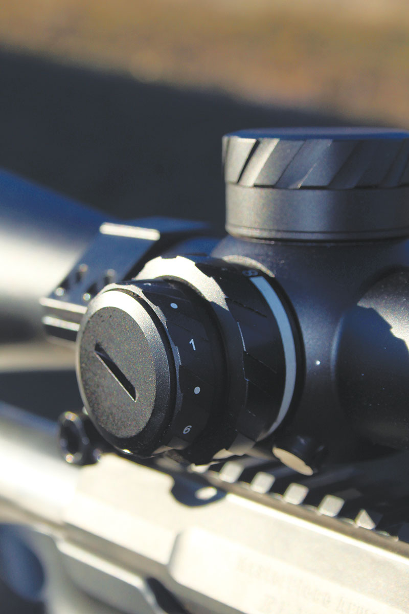 The left side of the scope holds an illumination wheel sandwiched outside of a raised parallax control surface. The parallax includes a wedge- style indicator instead of yardage numbers.